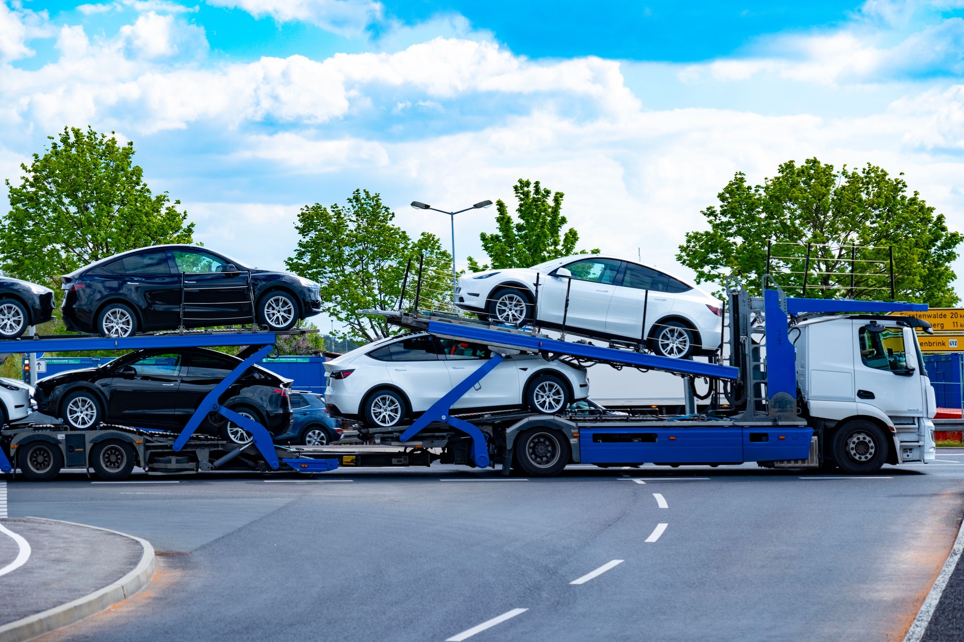 car transporter carrier transports new Tesla vehicles from Gigafactory Berlin-Brandenburg manufacturing plant along highway, Ev distribution, Berlin - April 26, 2024